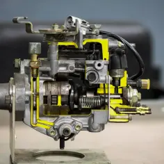 Przekrój pompy w samochodzie, ukazujący skomplikowany mechanizm i żółte elementy wewnętrzne.