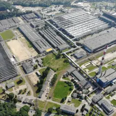 Ogromny kompleks przemysłowy, gdzie są produkowane opony Dębica. Widok z lotu ptaka na hale produkcyjne, komin i otaczającą zieleń.