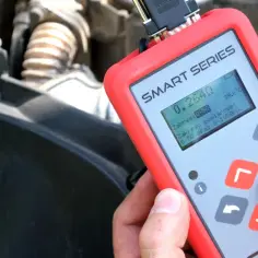 Tester wtryskiwaczy diesel w rękach mechanika, wyświetla wyniki pomiaru.