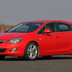 Czerwona Opel Astra na drodze. Kierowca zastanawia się, jaki akumulator będzie najlepszy do tego modelu.