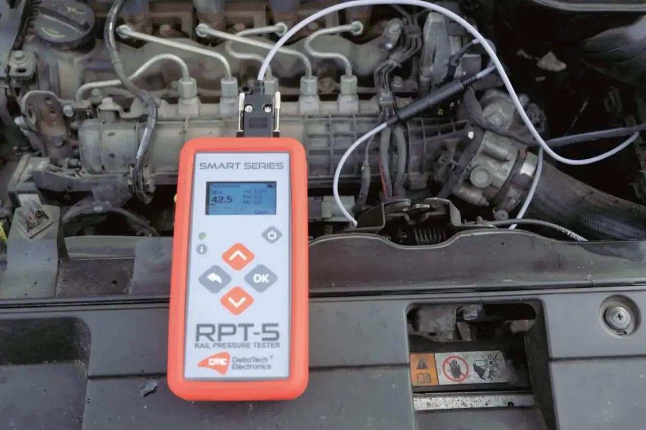 Tester RPT-5 mierzy prawidłowe ciśnienie na listwie wtryskowej common rail. Widać silnik i podłączone przewody.