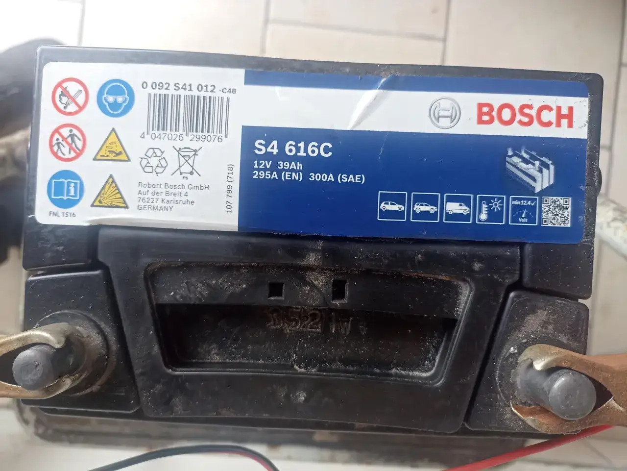 Akumulator Bosch S4 616C 12V 39Ah. Na etykiecie widoczne ostrzeżenia i symbolika, a także kod QR. Data produkcji akumulator bosch jest widoczna na naklejce.